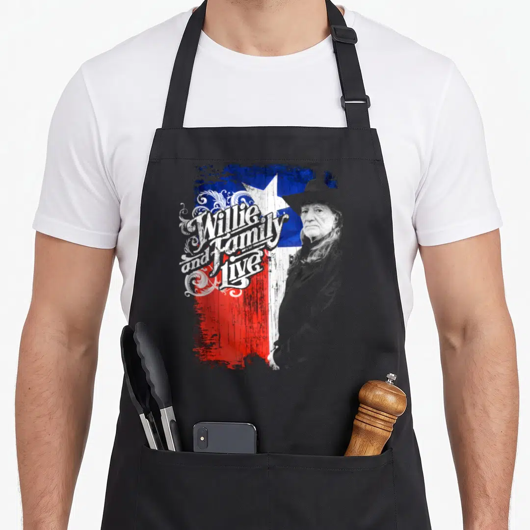 Willie texas apron - Willie Nelson portrait next to distressed Texas flag with swirling 'Willie and Family Live' text — shown on a black cotton canvas apron against a white background