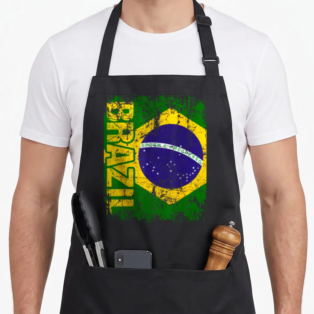 Brazil distressed apron - Vertical BRAZIL text over distressed green and yellow flag with blue circle and white stars — shown on a black cotton canvas apron against a white background