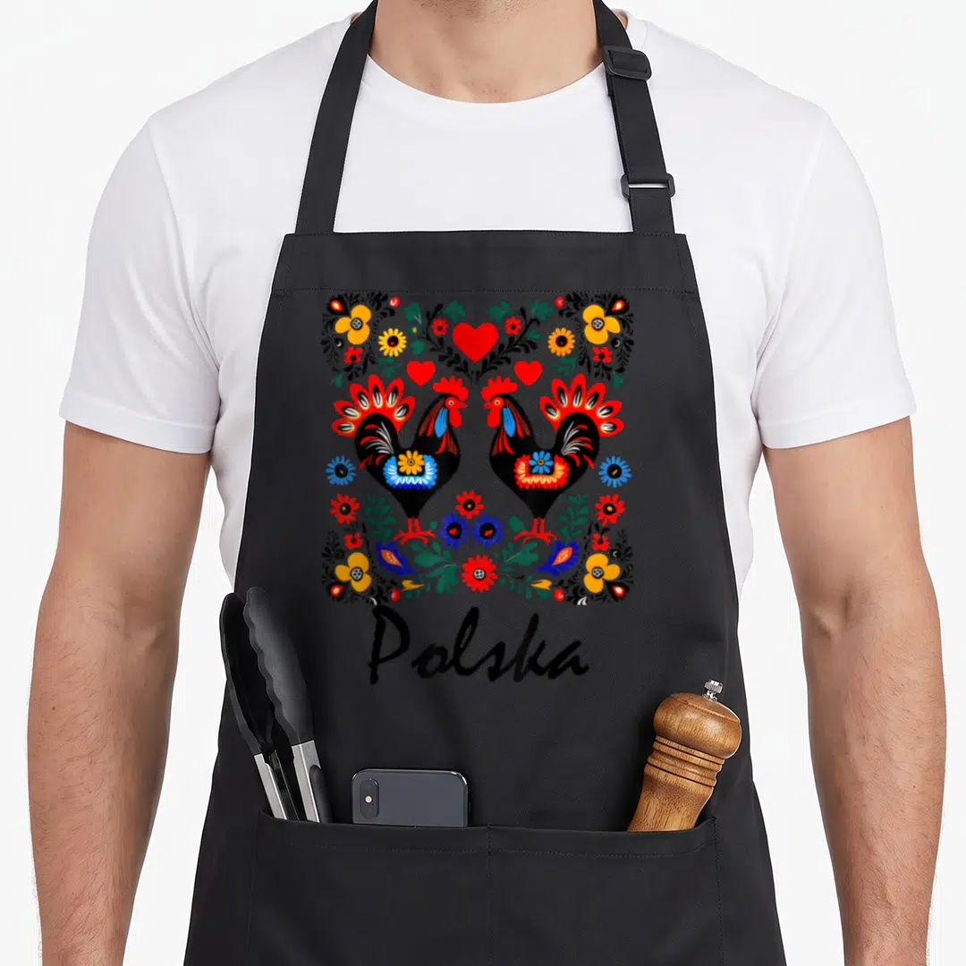 Wycinanki polish folk apron - Two black roosters facing each other with colorful flowers and Polska text below — shown on a black cotton canvas apron against a white background