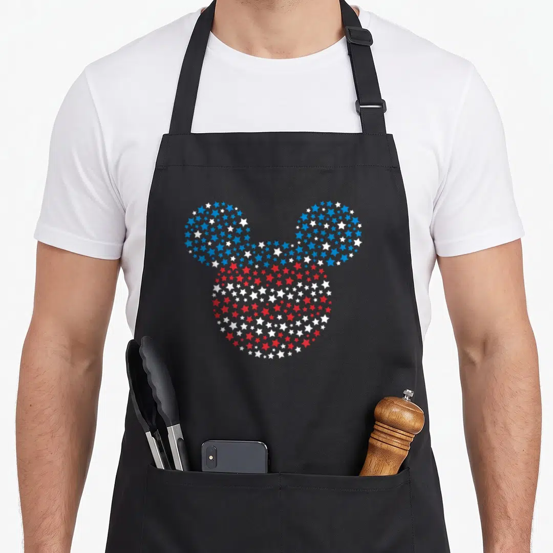 Blue love mice apron - Mickey head silhouette formed by blue white and red stars — shown on a black cotton canvas apron against a white background
