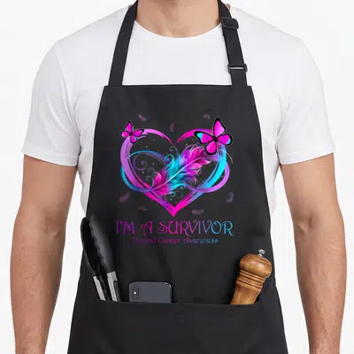 Thyroid butterfly apron - Heart with feather and two butterflies above I'm A Survivor text — shown on a black cotton canvas apron against a white background
