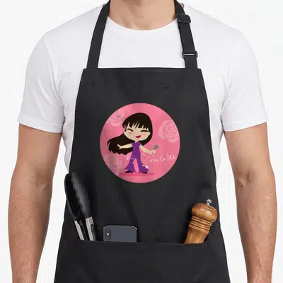 Como cumbia apron - Cartoon woman in purple holding mic in pink circle with roses and Como la Flor text — shown on a black cotton canvas apron against a white background