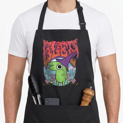 Smiling heavy apron - Green creature purple hat BLEED text pink flowers light blue circle cartoon art — shown on a black cotton canvas apron against a white background