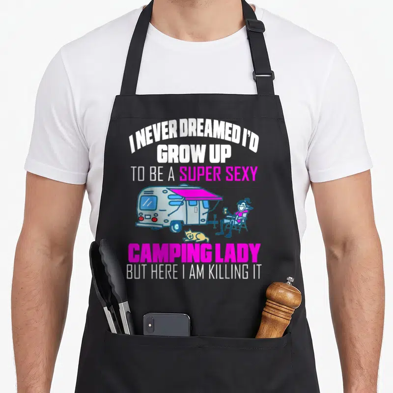 Grow camping apron - Camping lady sitting near camper van with pink awning and lying yellow dog under funny quote — shown on a black cotton canvas apron against a white background