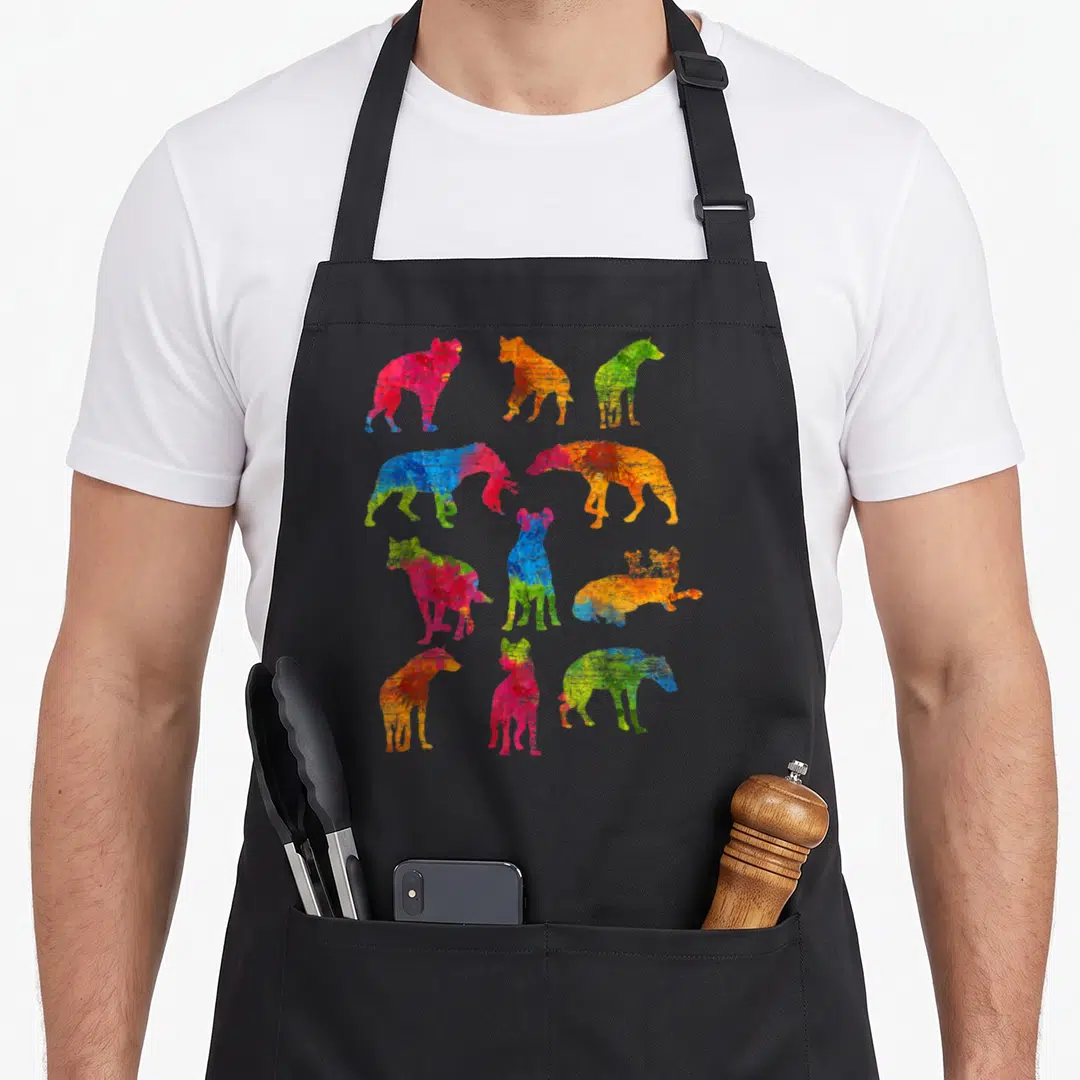 Hyena colorful aprons - Ten watercolor dog silhouettes in blue red yellow green orange and pink scattered in four rows — shown on a black cotton canvas apron against a white background