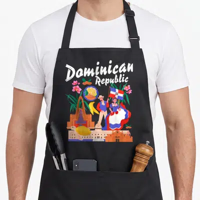 Dominican fancy apron - Cartoon couple holding flag with turtle orchids banana and architecture under Dominican — shown on a black cotton canvas apron against a white background