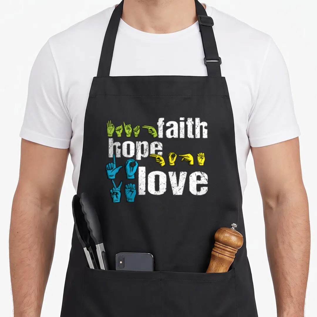 Hope asl sign for apron - Stacked white text faith hope love with green yellow and blue ASL hands — shown on a black cotton canvas apron against a white background