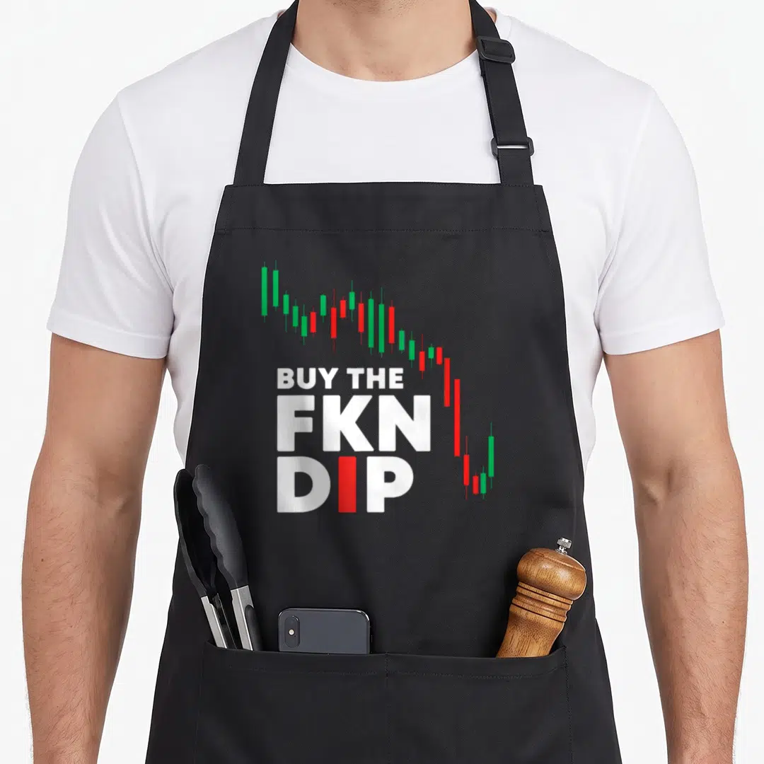Fkn stock aprons - Stacked white text BUY THE FKN DIP with red I and descending green red candlestick chart — shown on a black cotton canvas apron against a white background