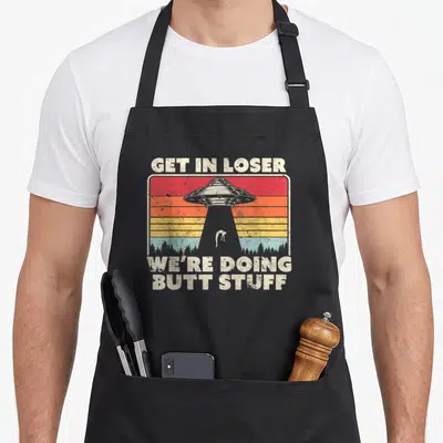 Ufo get loser apron - Retro UFO abduction scene with striped sunset and sarcastic text — shown on a black cotton canvas apron against a white background