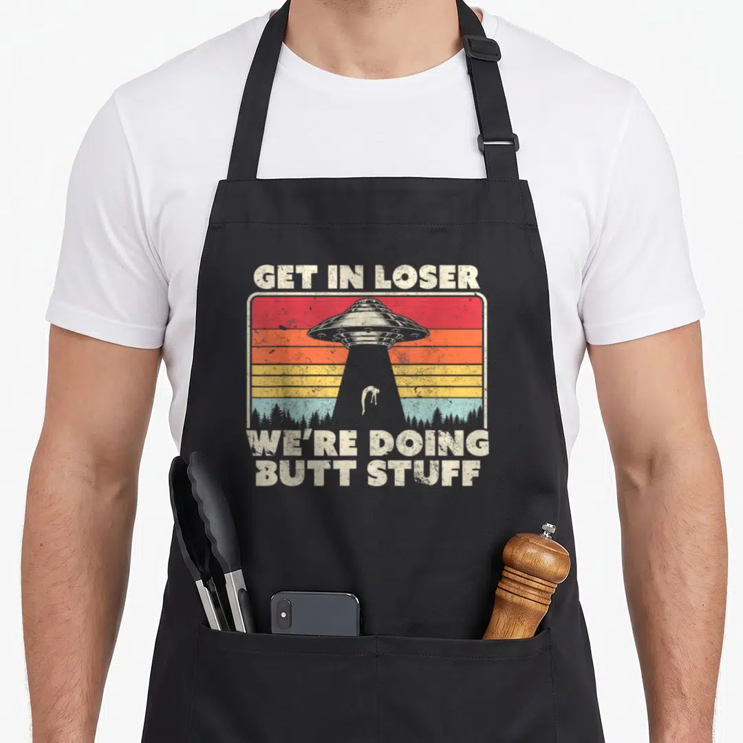 Ufo get loser apron - Retro UFO abduction scene with striped sunset and sarcastic text — shown on a black cotton canvas apron against a white background