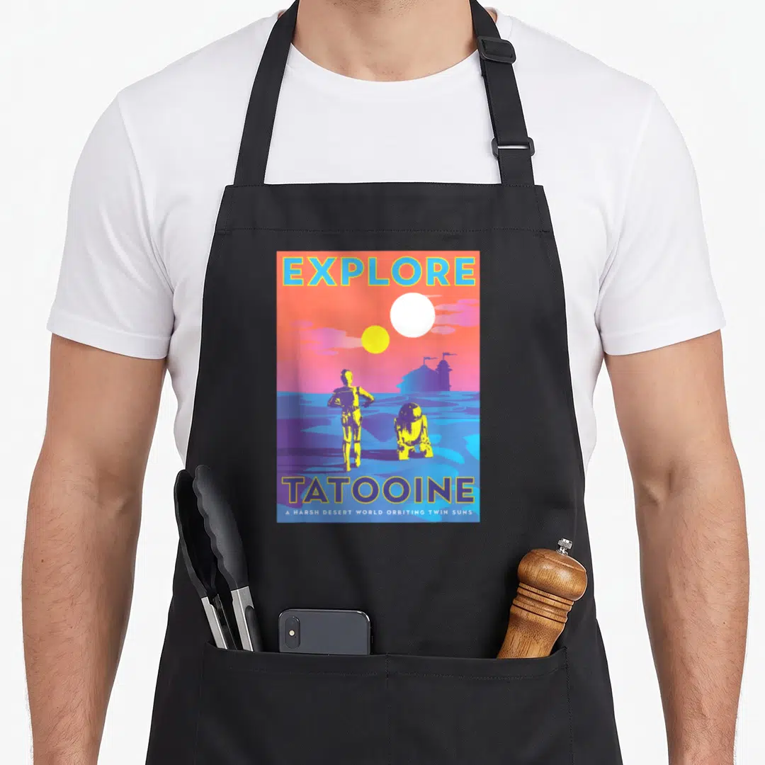 3po new hope apron - Retro poster art of Tatooine with two suns and figures in yellow purple orange and blue — shown on a black cotton canvas apron against a white background