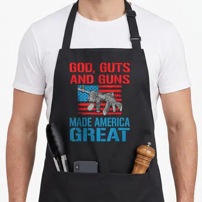 Gut gun apron - Rifle on distressed flag with red and blue stencil text reading GOD GUTS AND GUNS MADE AMERICA GREAT — shown on a black cotton canvas apron against a white background