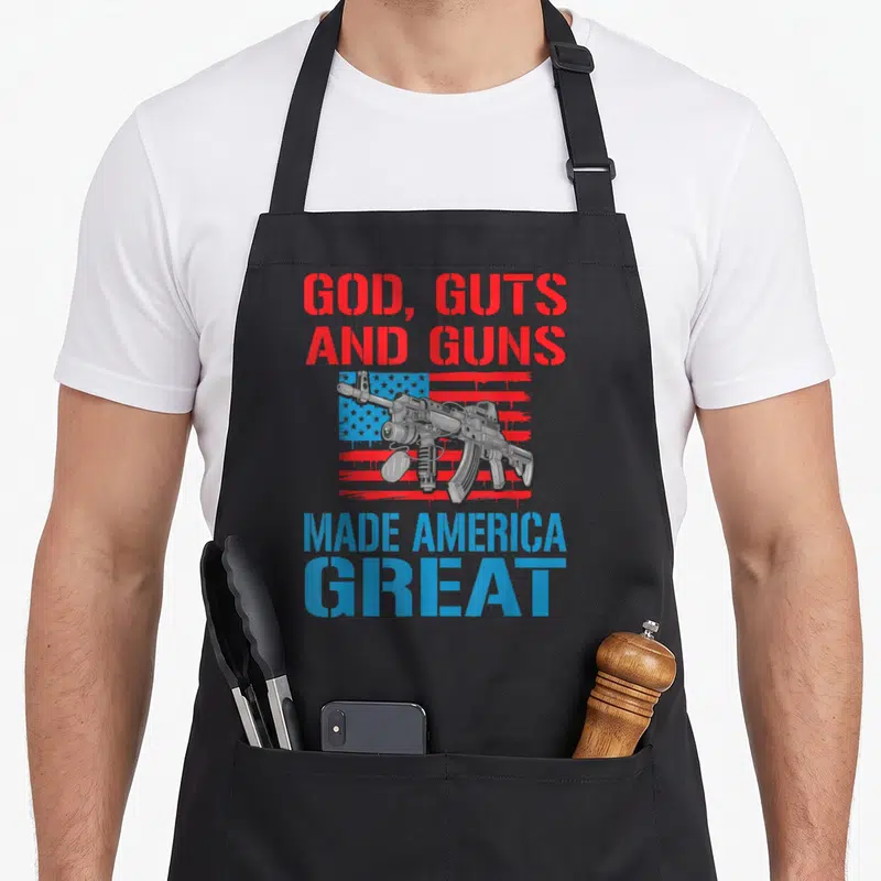 Gut gun apron - Rifle on distressed flag with red and blue stencil text reading GOD GUTS AND GUNS MADE AMERICA GREAT — shown on a black cotton canvas apron against a white background