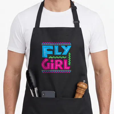 Distressed hip aprons - FLY GIRL text in blue and pink with green zigzag and geometric triangle borders — shown on a black cotton canvas apron against a white background