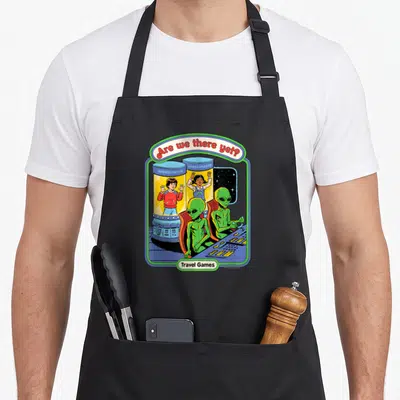Steven game aprons - Two green aliens at console with children in experiment cylinders under arch text — shown on a black cotton canvas apron against a white background