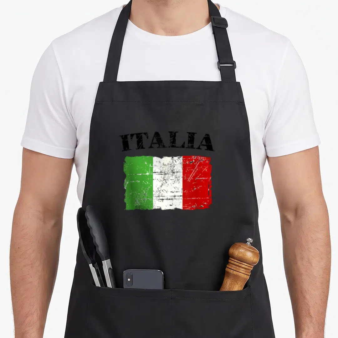 Flag italy apron - Arched black Italia text above a distressed green white and red rectangular flag graphic — shown on a black cotton canvas apron against a white background