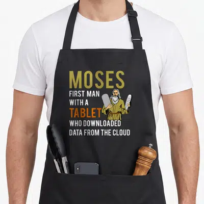 Jewish passover apron - Moses holding two tablets next to stacked text about downloading data from the cloud — shown on a black cotton canvas apron against a white background
