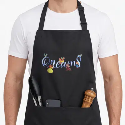 75th cinderella apron - Dreams script with three mice and two birds in blue brown yellow cartoon style — shown on a black cotton canvas apron against a white background