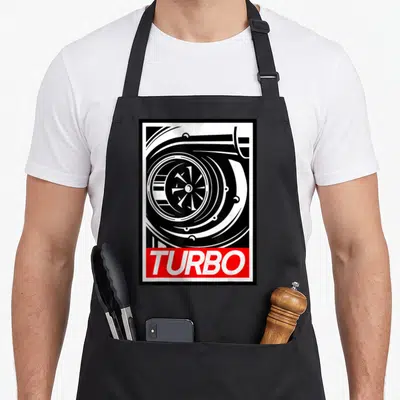 Boost racing apron - Black and white turbocharger line art above a red rectangle with white TURBO text — shown on a black cotton canvas apron against a white background