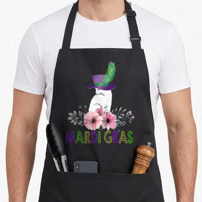 Cat new orleans apron - White rabbit in purple top hat with peacock feather above pink flowers and MARDI GRAS text — shown on a black cotton canvas apron against a white background