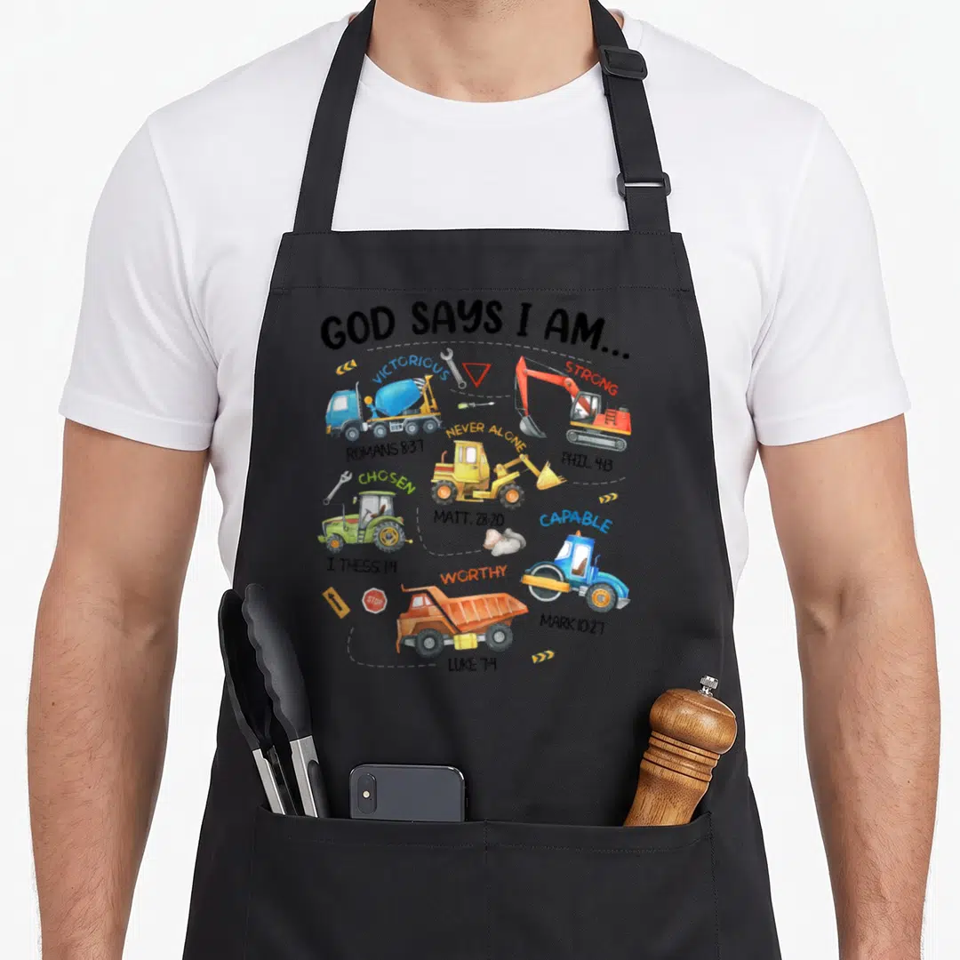 Construction god says i am apron - Cartoon cement truck excavator and dump truck with Bible verses and construction — shown on a black cotton canvas apron against a white background