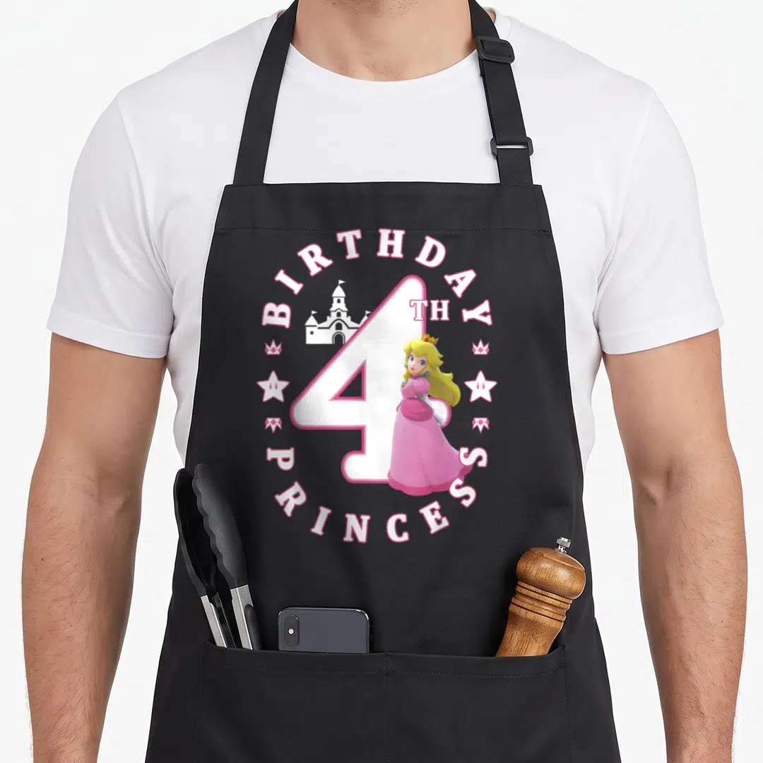 4th princess apron - Princess Peach standing before a castle inside a pink and white circular birthday text design — shown on a black cotton canvas apron against a white background