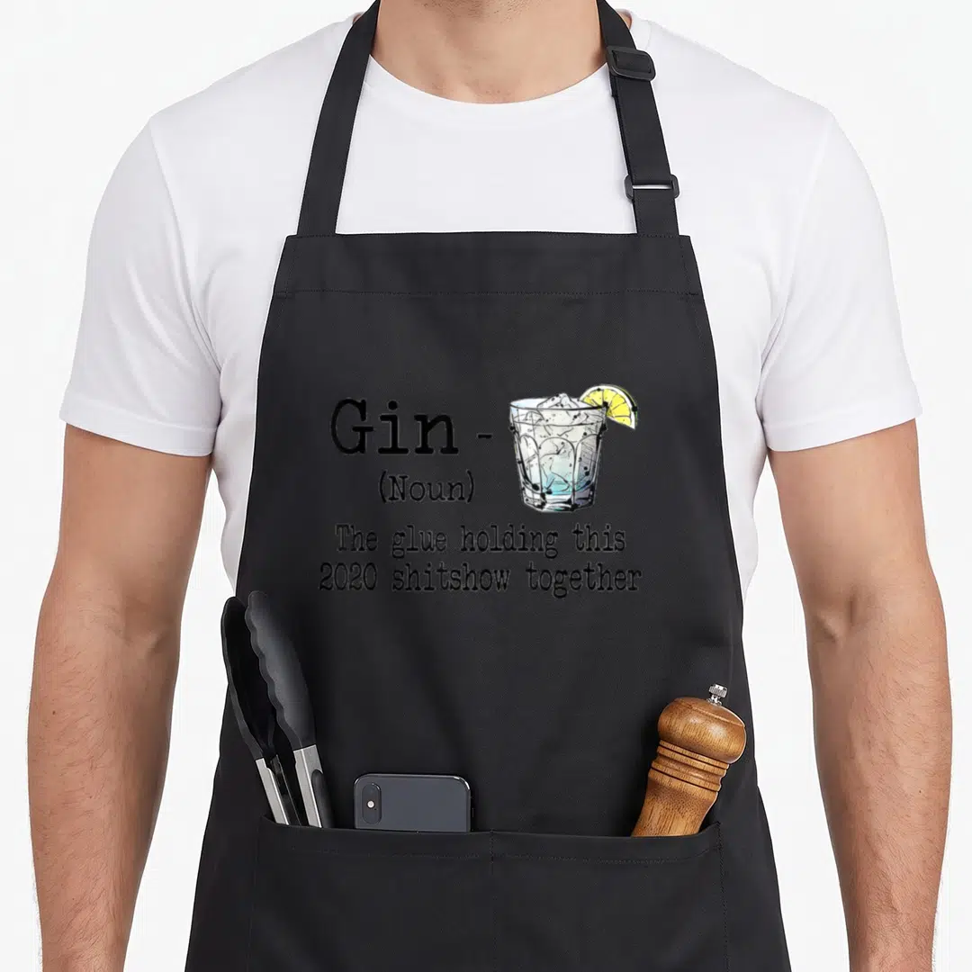Gin holding apron - Gin dictionary definition text next to a cocktail glass with yellow lime slice on black background — shown on a black cotton canvas apron against a white background