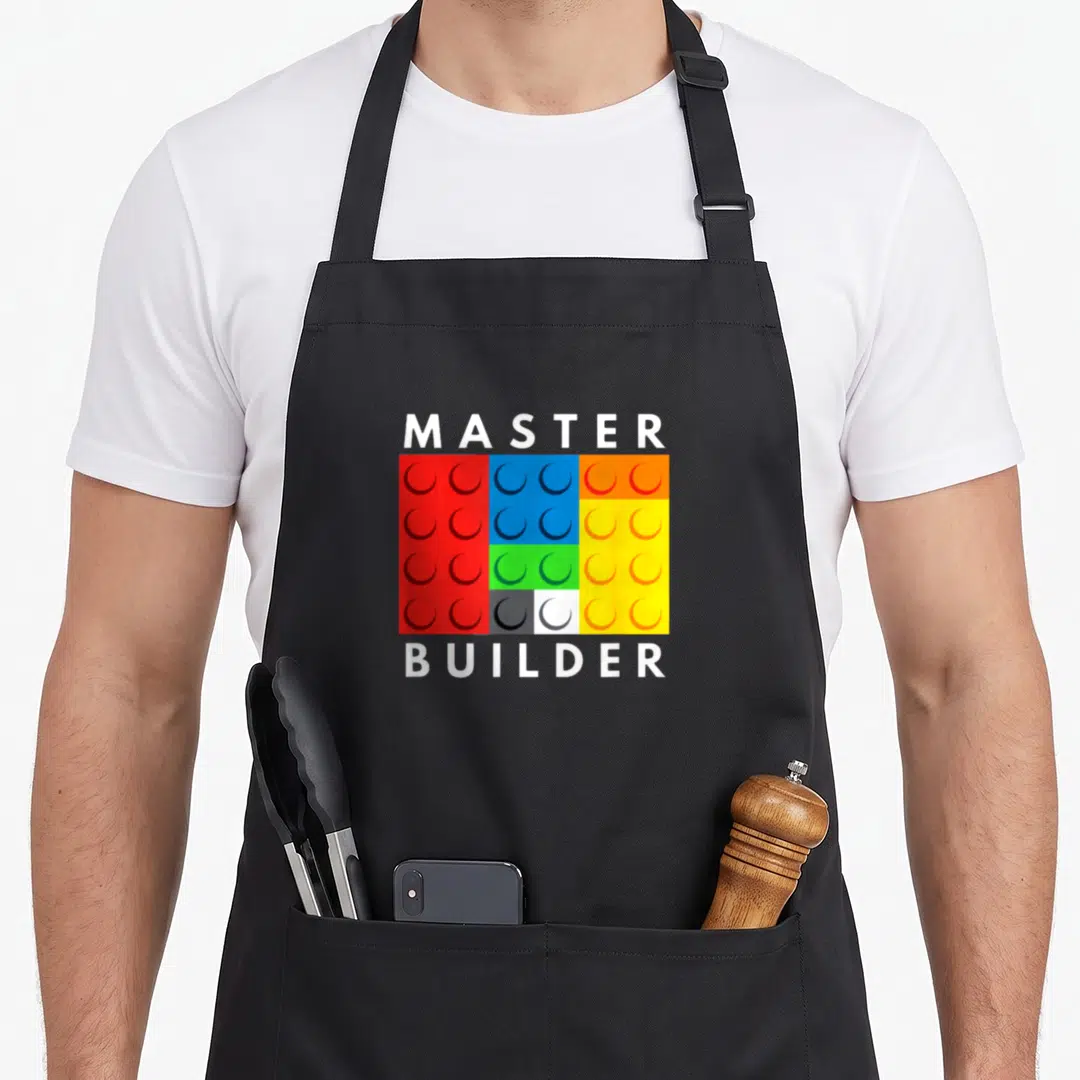 Master block & apron - MASTER and BUILDER text surrounding a grid of red, blue, yellow, green, white, and orange — shown on a black cotton canvas apron against a white background