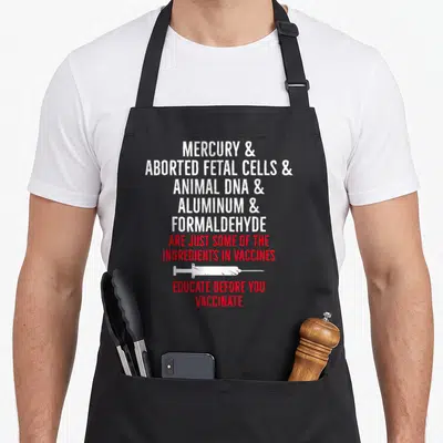 Anti vaccine apron - Stacked text listing vaccine ingredients with a horizontal white syringe graphic in distressed — shown on a black cotton canvas apron against a white background
