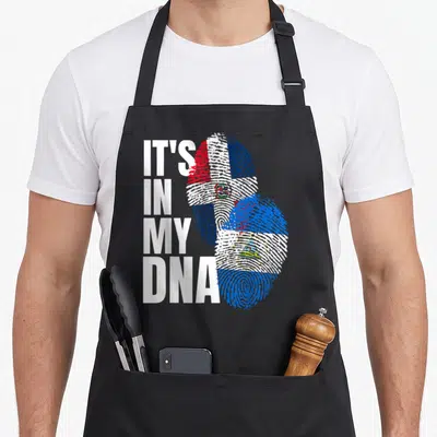 Nicaraguan dominican heritage aprons - Stacked white text next to two overlapping fingerprints filled with red white — shown on a black cotton canvas apron against a white background