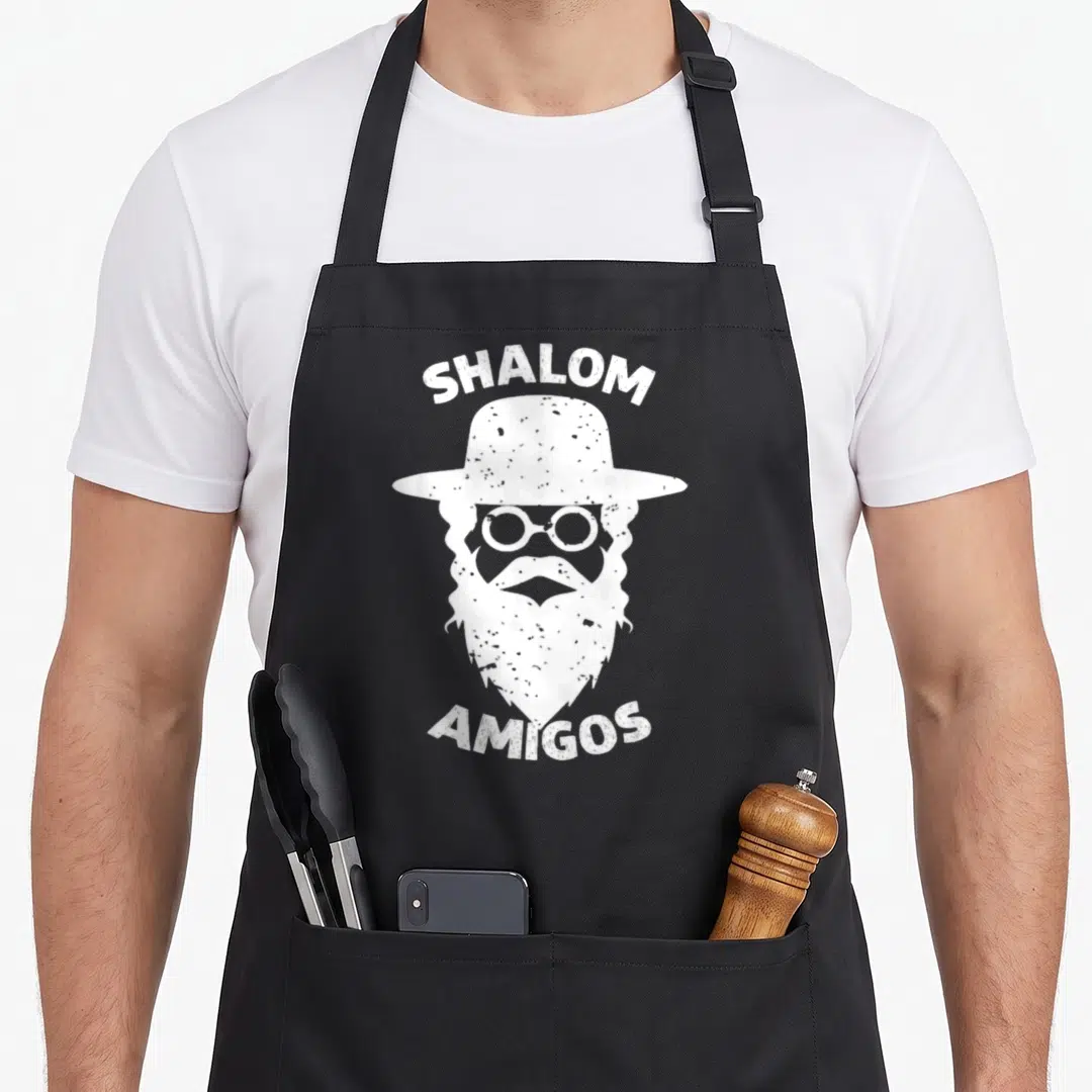 Shalom jewish apron - White distressed graphic of bearded man in hat and glasses with SHALOM AMIGOS text — shown on a black cotton canvas apron against a white background