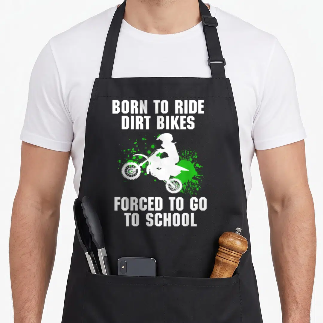 Supercross bike apron - White dirt bike rider silhouette over green splatter with Born to Ride and Forced to Go — shown on a black cotton canvas apron against a white background