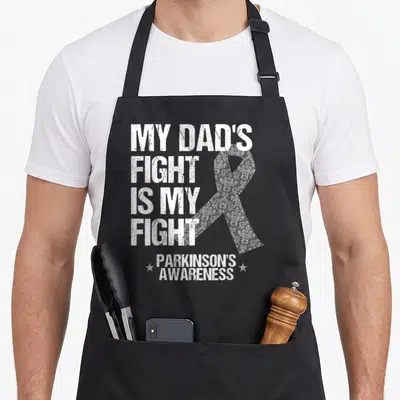 Parkinson disease ribbon apron - My Dad's Fight Is My Fight text with floral ribbon and two stars — shown on a black cotton canvas apron against a white background