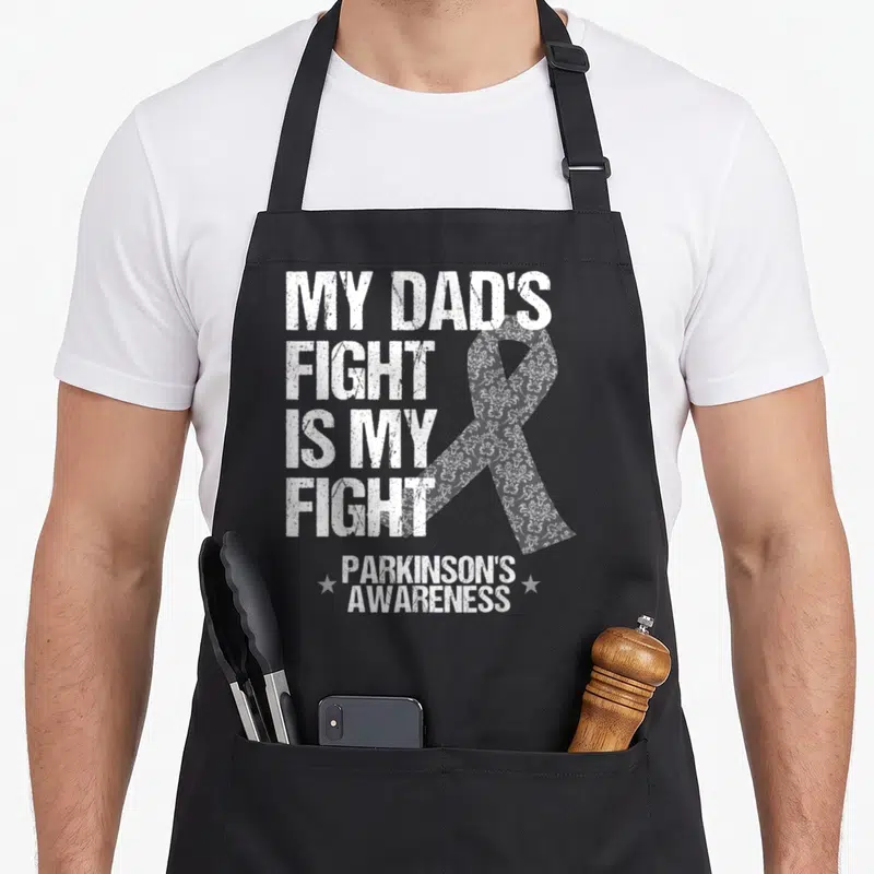 Parkinson disease ribbon apron - My Dad's Fight Is My Fight text with floral ribbon and two stars — shown on a black cotton canvas apron against a white background