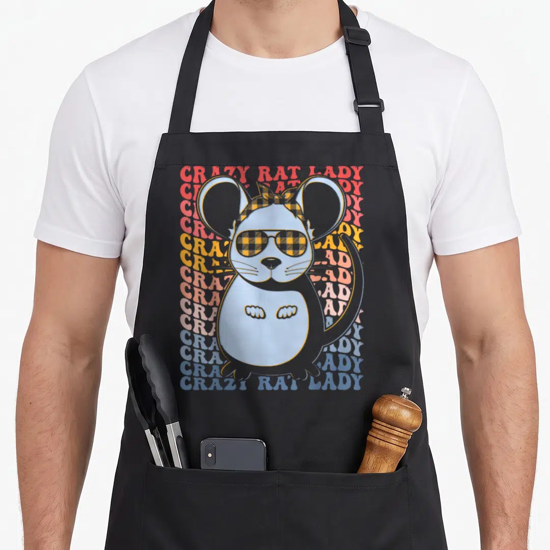 Groovy pet apron - Cartoon blue rat with plaid bow and sunglasses over stacked colorful text lines — shown on a black cotton canvas apron against a white background