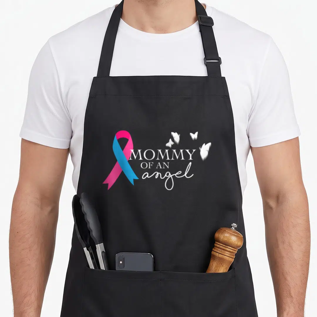 National angels in aprons - Pink and blue ribbon with MOMMY OF AN angel text and four white butterflies — shown on a black cotton canvas apron against a white background