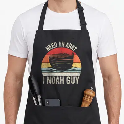 Catch christian apron - Retro striped sun with grey ark and text Need An Ark I Noah Guy — shown on a black cotton canvas apron against a white background