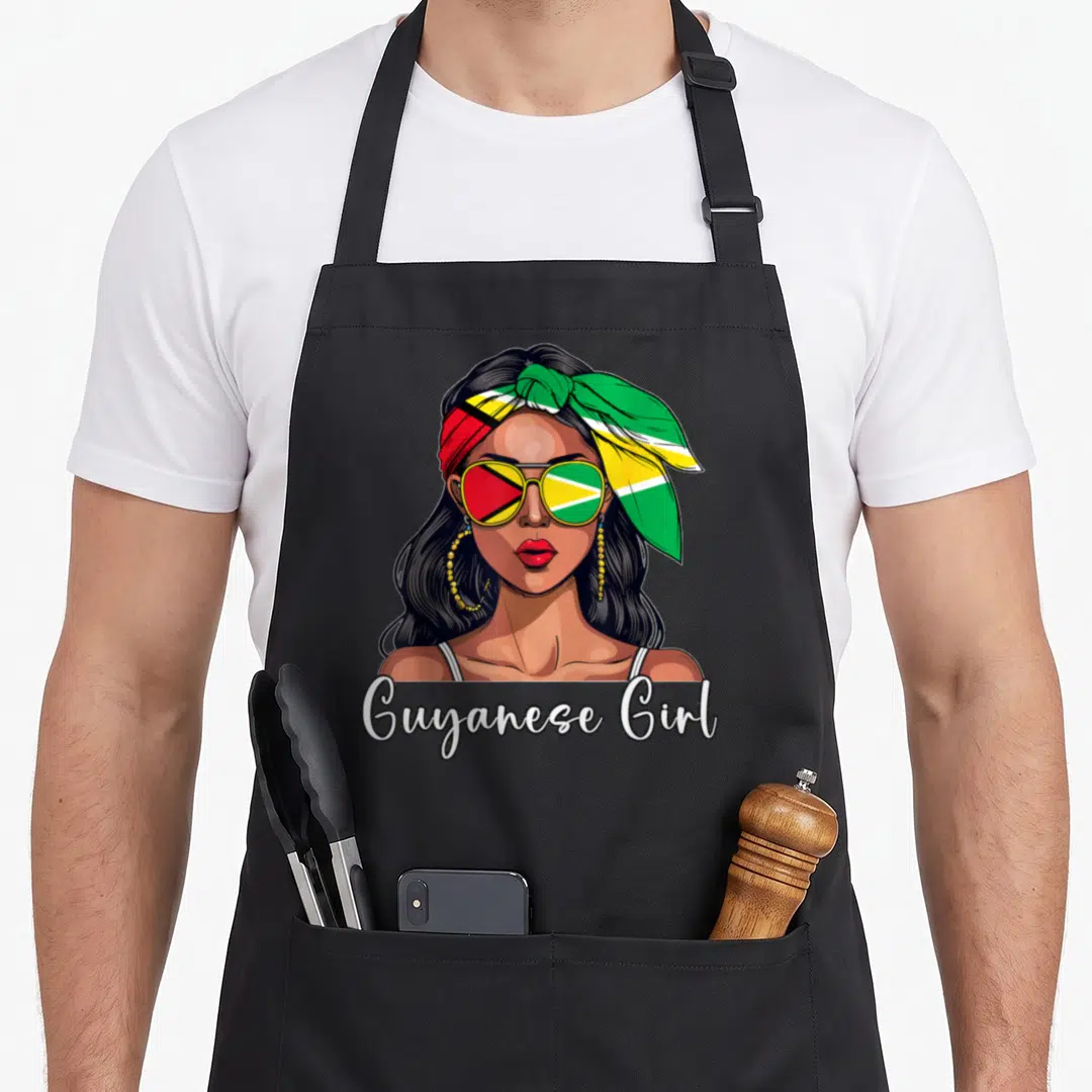Souvenir guyana apron - Woman portrait with flag sunglasses and headscarf and Guyanese Girl text — shown on a black cotton canvas apron against a white background