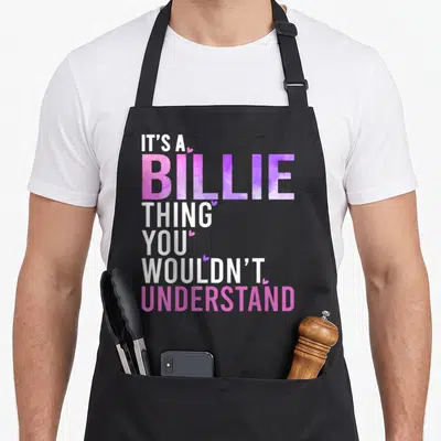 Billie groovy personalized for women apron - Stacked text IT'S A BILLIE THING YOU WOULDN'T UNDERSTAND in white pink — shown on a black cotton canvas apron against a white background