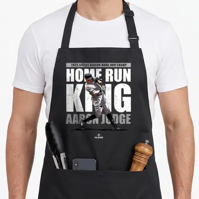 Single new york apron - Aaron Judge baseball player photo overlapping HOME RUN KING text in white grey and black — shown on a black cotton canvas apron against a white background