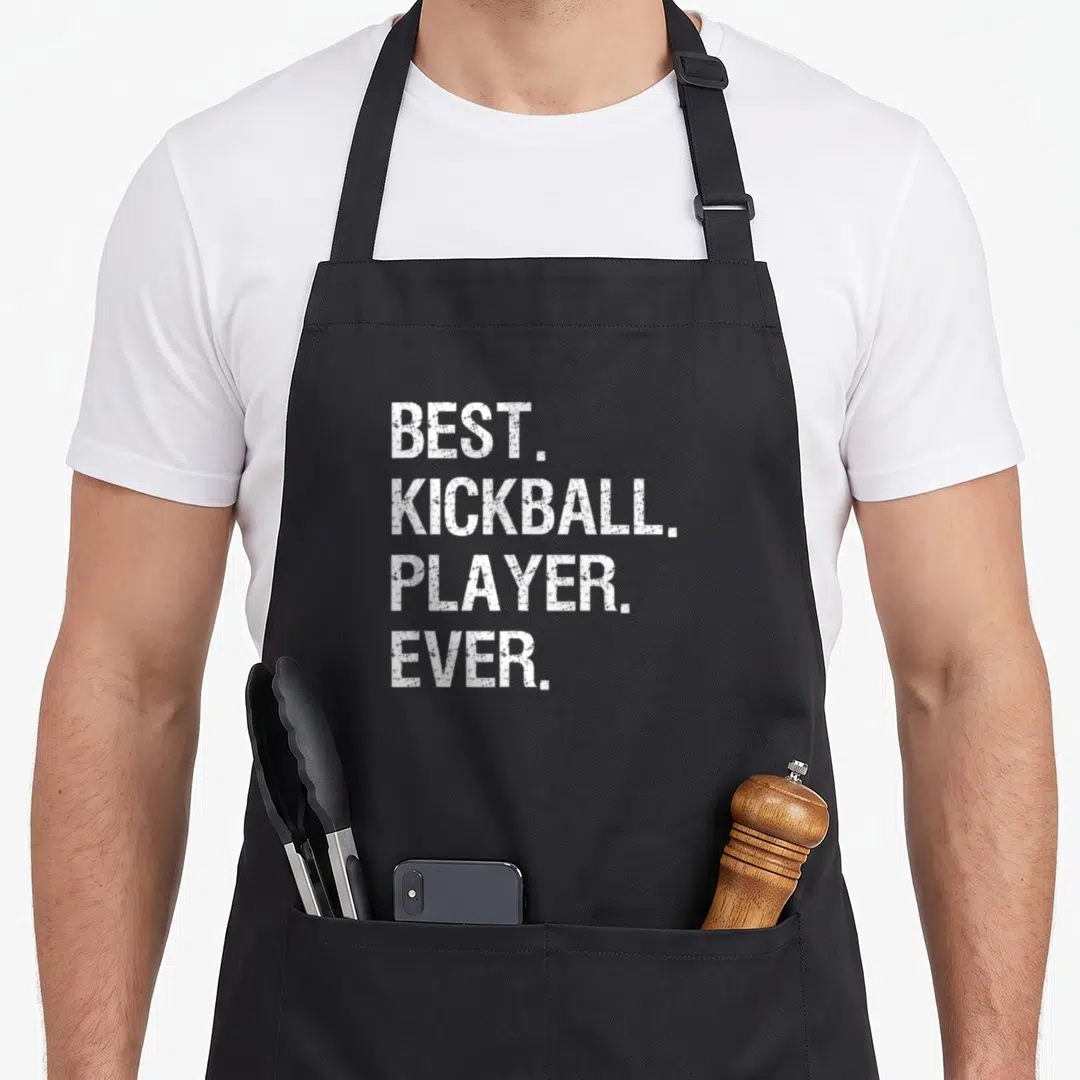 Funny player kickball apron - White stacked text BEST KICKBALL PLAYER EVER on black fabric — shown on a black cotton canvas apron against a white background