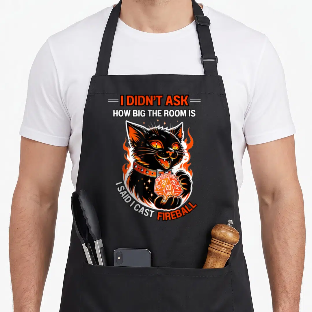 Didnt cat apron - Black cat holding orange d20 die surrounded by flames with I didn't ask how big the room is said I — shown on a black cotton canvas apron against a white background