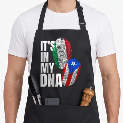 Puerto italian flag apron - Stacked IT'S IN MY DNA text beside two fingerprints filled with Italian and Puerto Rican — shown on a black cotton canvas apron against a white background