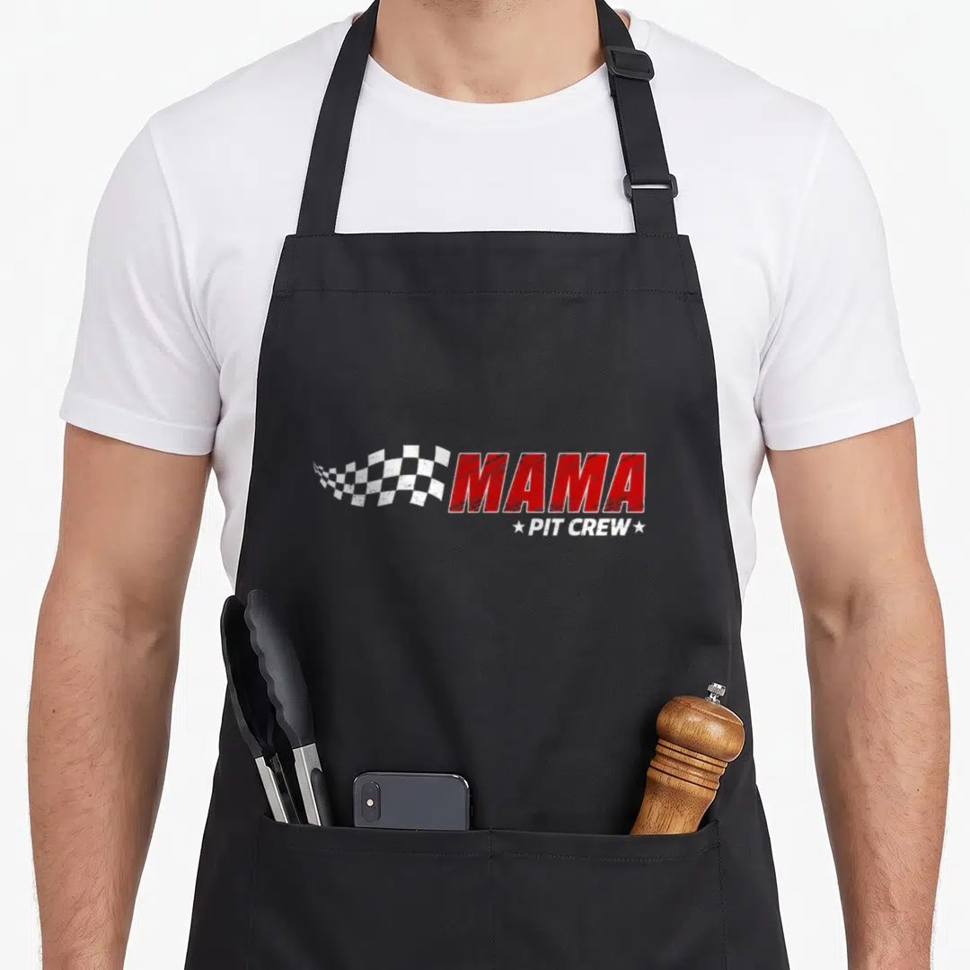Mama pit car apron - Red MAMA text with white PIT CREW and waving checkered flag on grey background — shown on a black cotton canvas apron against a white background