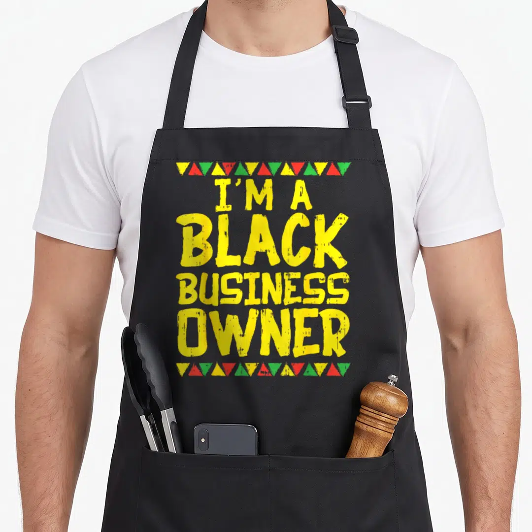 Business african american aprons - Yellow text reading I'M A BLACK BUSINESS OWNER bordered by red green and yellow — shown on a black cotton canvas apron against a white background