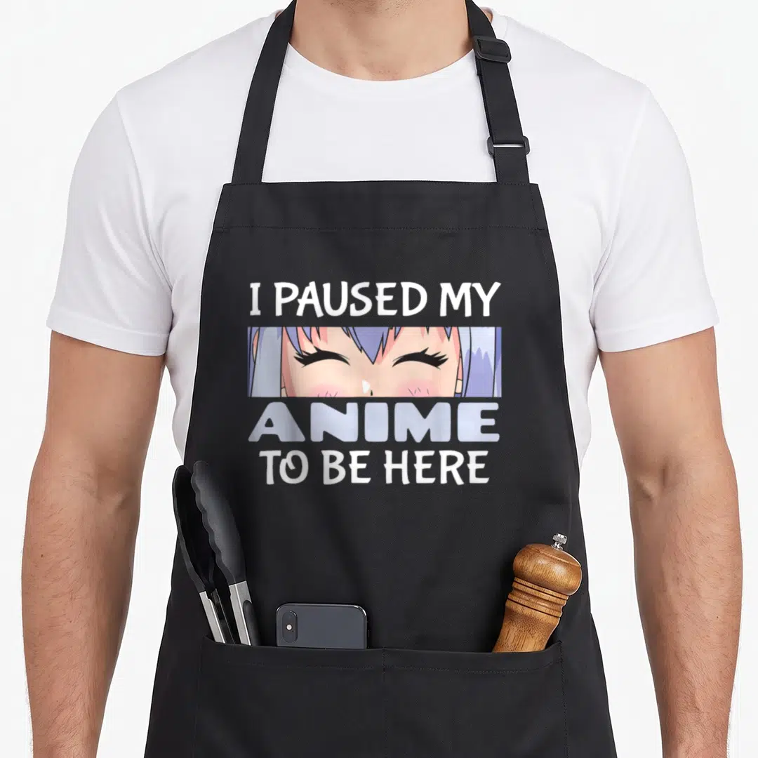 Japanese anime apron - Anime girl eye crop with text I paused my anime to be here — shown on a black cotton canvas apron against a white background