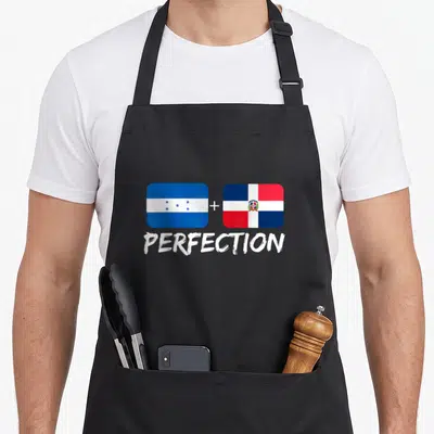 Dominican perfection heritage aprons - Two flags separated by a plus sign above the word PERFECTION in blue white — shown on a black cotton canvas apron against a white background