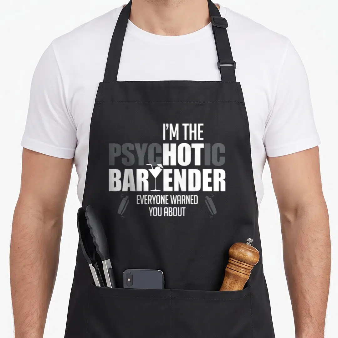 Psychotic bartender apron - Stacked text I'm the psychotic bartender everyone warned you about with martini glass — shown on a black cotton canvas apron against a white background