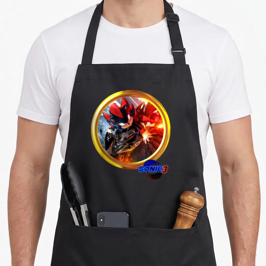 Shadow motorcycle apron - Photo of Shadow the Hedgehog on a bike inside a gold ring with SONIC 3 logo — shown on a black cotton canvas apron against a white background