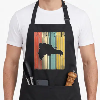 Funny dominican republic apron - Grey Dominican Republic map silhouette over red, cream, teal, yellow, and white — shown on a black cotton canvas apron against a white background